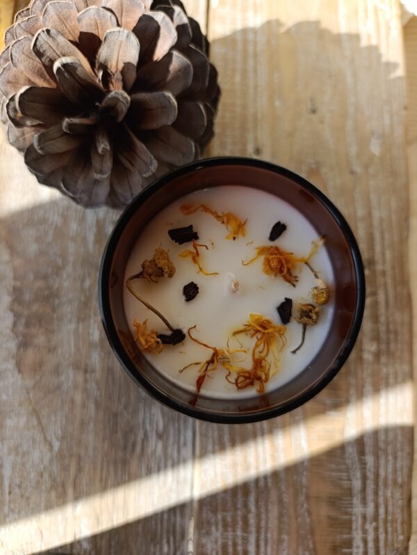 Bougie fleuris avec des fleurs naturelles de camomille, soucis et hibiscus