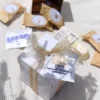 Boîte cadeau blanche contenant 5 fondants parfumés artisanaux, une mini fiche explicative et un fondant offert avec l'inscription Merci
