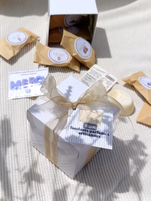 Boîte cadeau blanche contenant 5 fondants parfumés artisanaux, une mini fiche explicative et un fondant offert avec l'inscription Merci