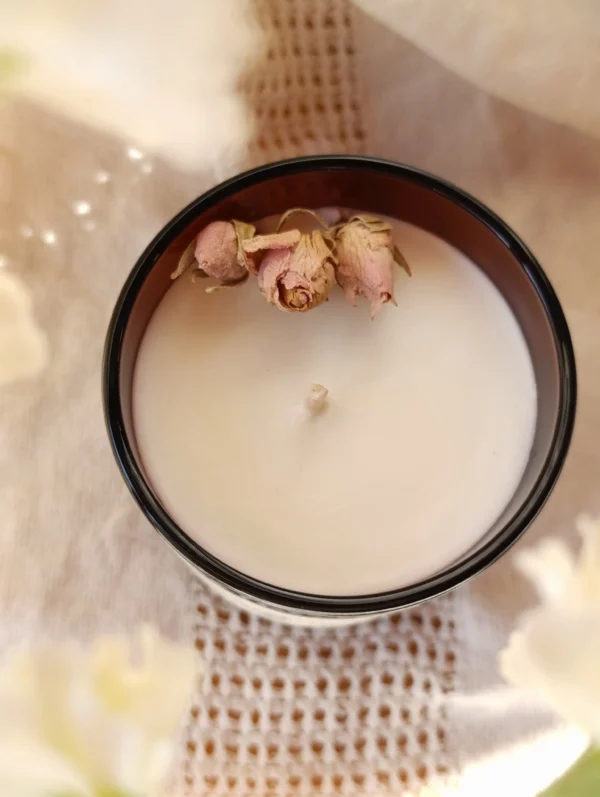 Pour décorer la bougie Verger au parfum Pêche, il y a trois roses l'une à côté de l'autre pour un côté élégant.